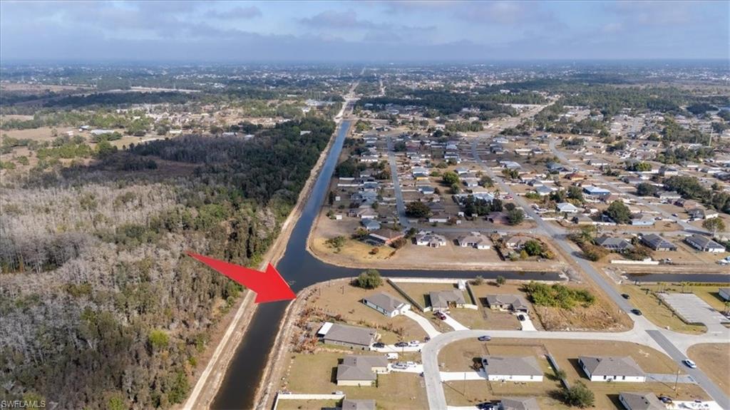 Aerial view of property's location with nearby suburban area and a nearby body of water