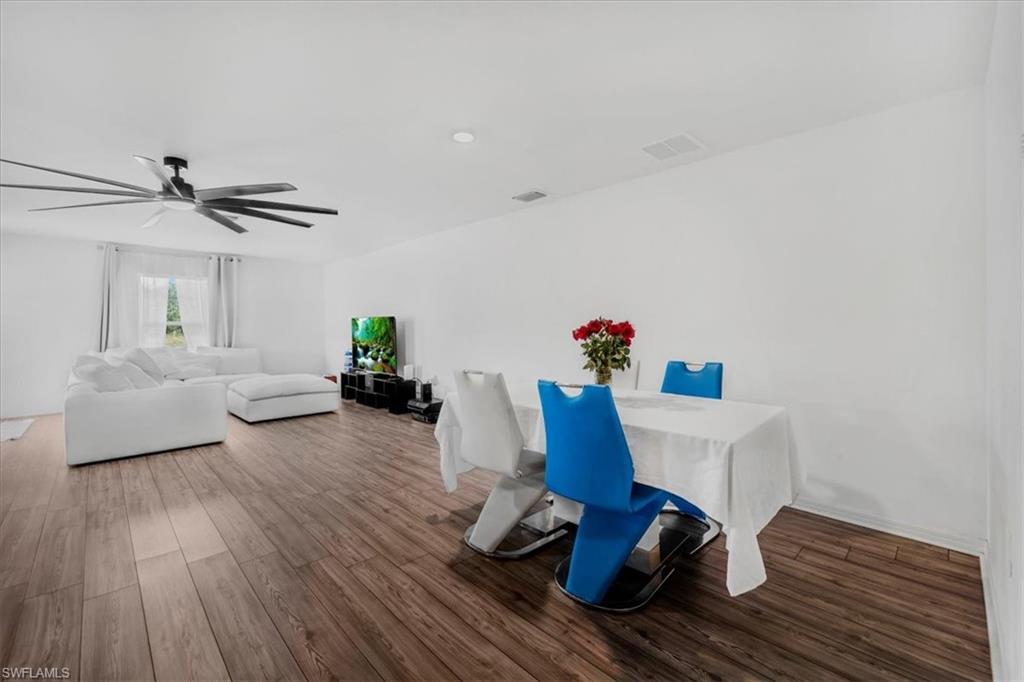 Dining room featuring dark wood-style floors and a ceiling fan