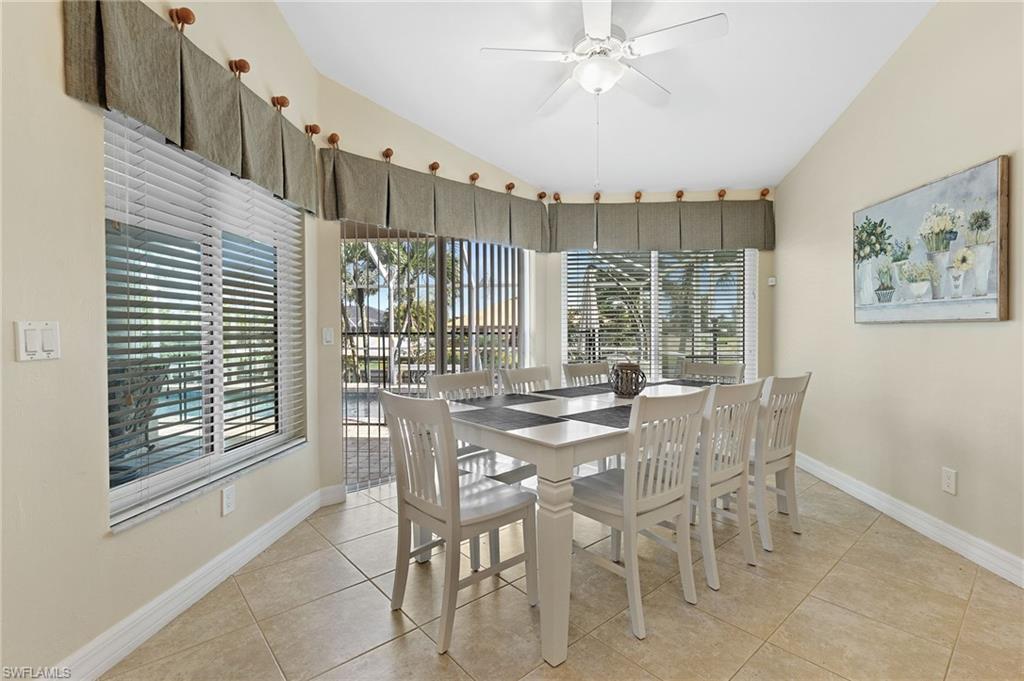 Dining space featuring ceiling fan, vaulted ceiling, and light tile patterned floors
