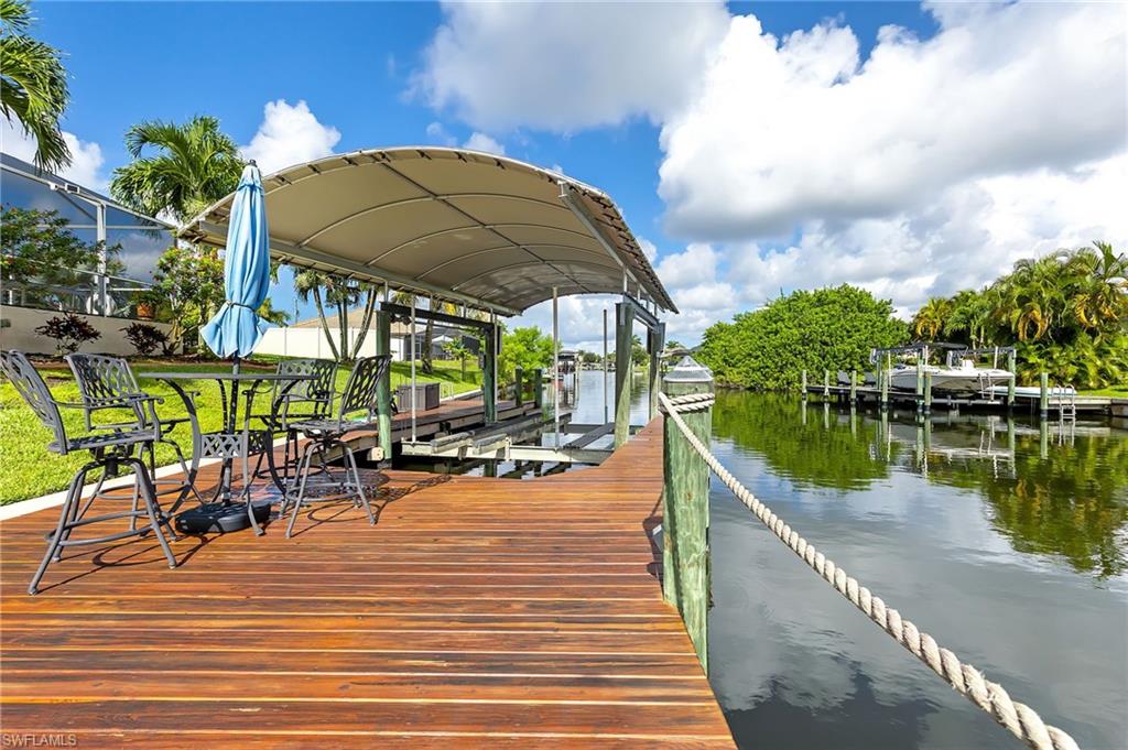 Dock area featuring boat lift and a water view