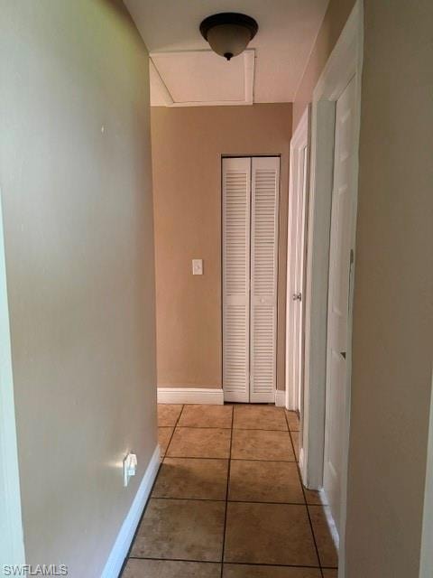 Hall with baseboards and light tile patterned flooring