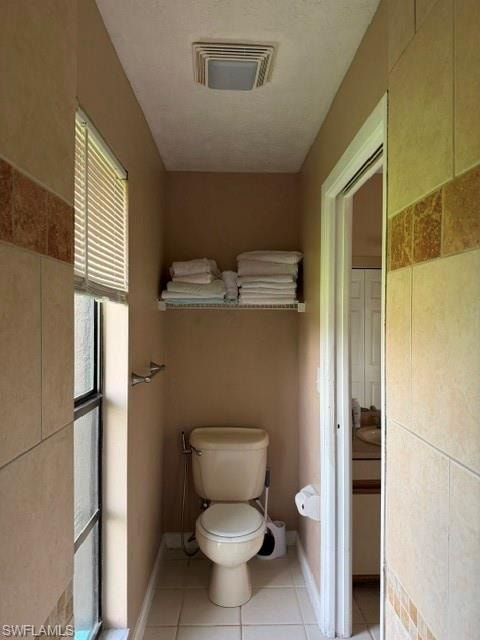Half bathroom with light tile patterned floors and a textured ceiling