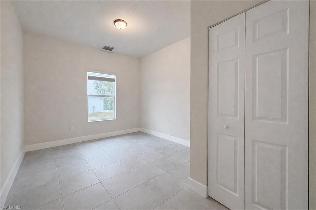 Unfurnished room with ceiling fan and light tile patterned floors