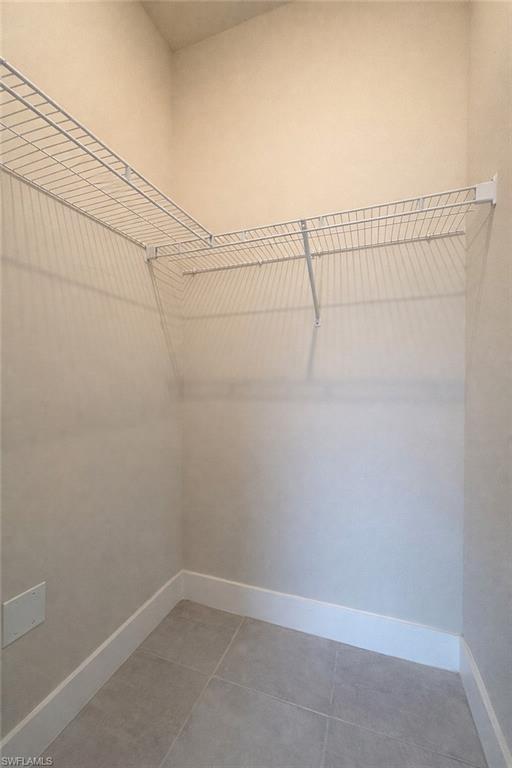 Unfurnished room featuring baseboards and light tile patterned flooring