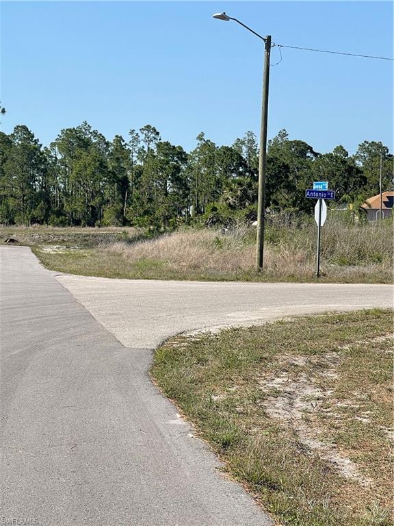 View of asphalt road featuring street lights