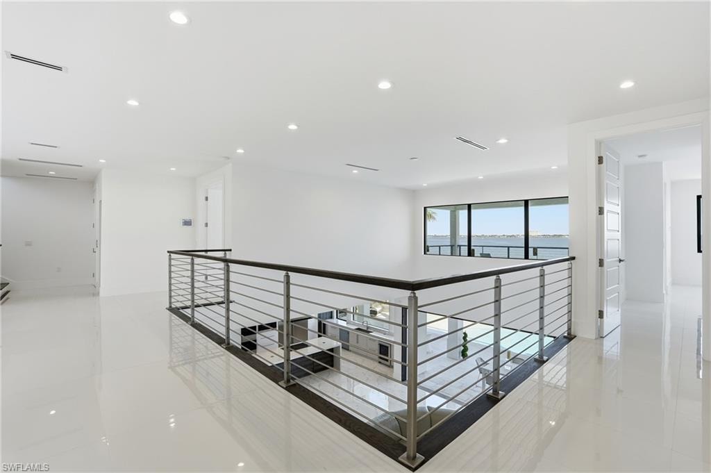 Hallway featuring recessed lighting, light tile patterned floors, and an upstairs landing
