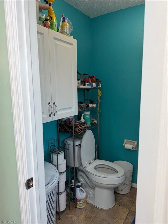 Bathroom with toilet and a textured ceiling