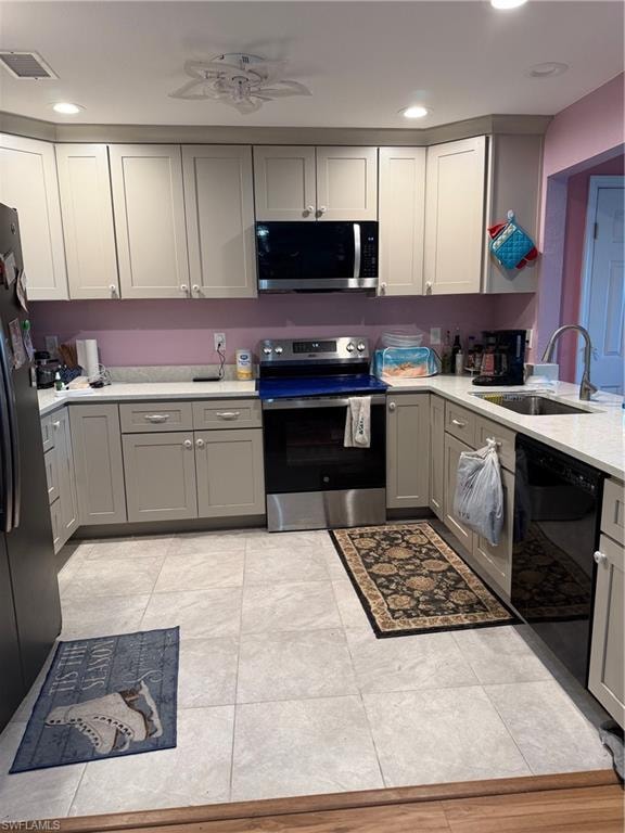 Kitchen with gray cabinetry, stainless steel electric range oven, a ceiling fan, dishwashing machine, and fridge