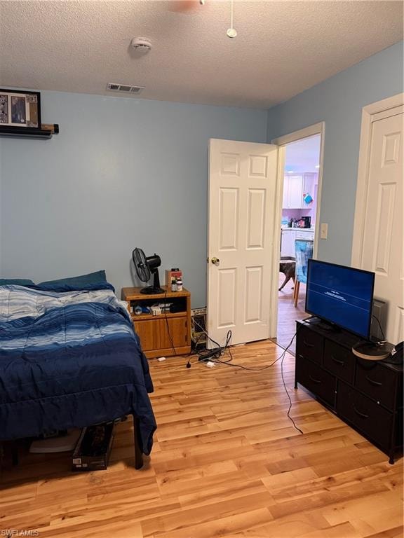 Bedroom featuring light wood-type flooring and a textured ceiling