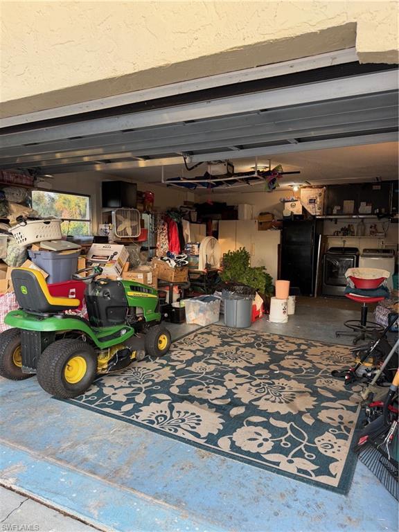 Garage with refrigerator and washer and dryer