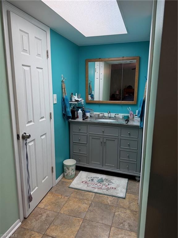 Bathroom with vanity and light stone finish flooring
