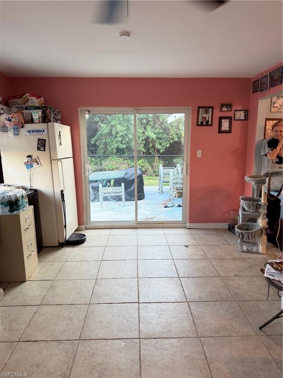 Unfurnished dining area with light tile patterned flooring and baseboards