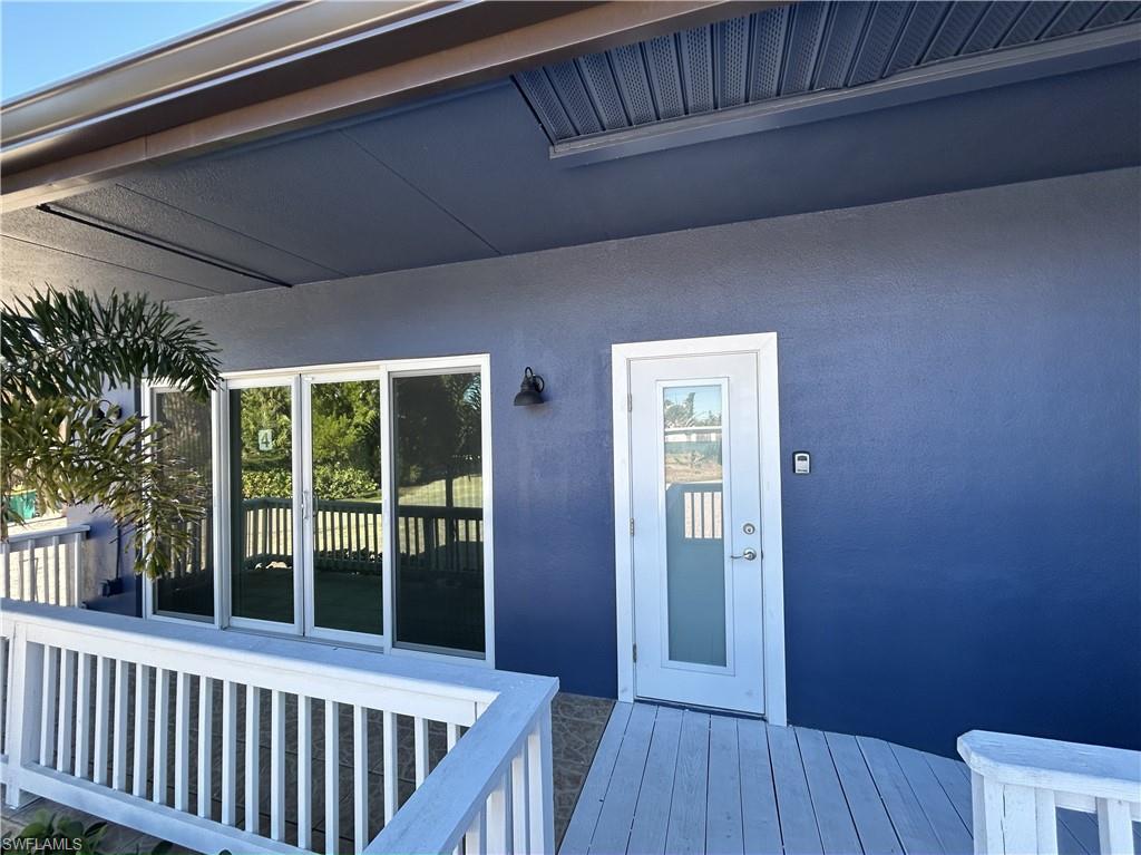 Property entrance featuring a deck and stucco siding