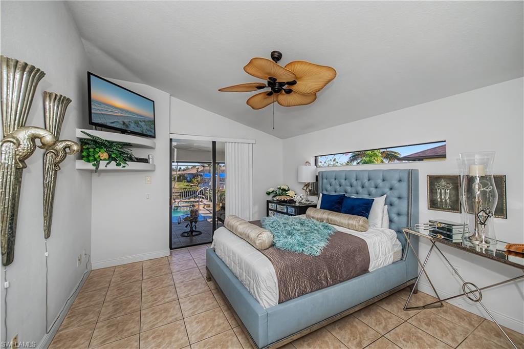 Bedroom with access to outside, light tile patterned floors, lofted ceiling, and a ceiling fan
