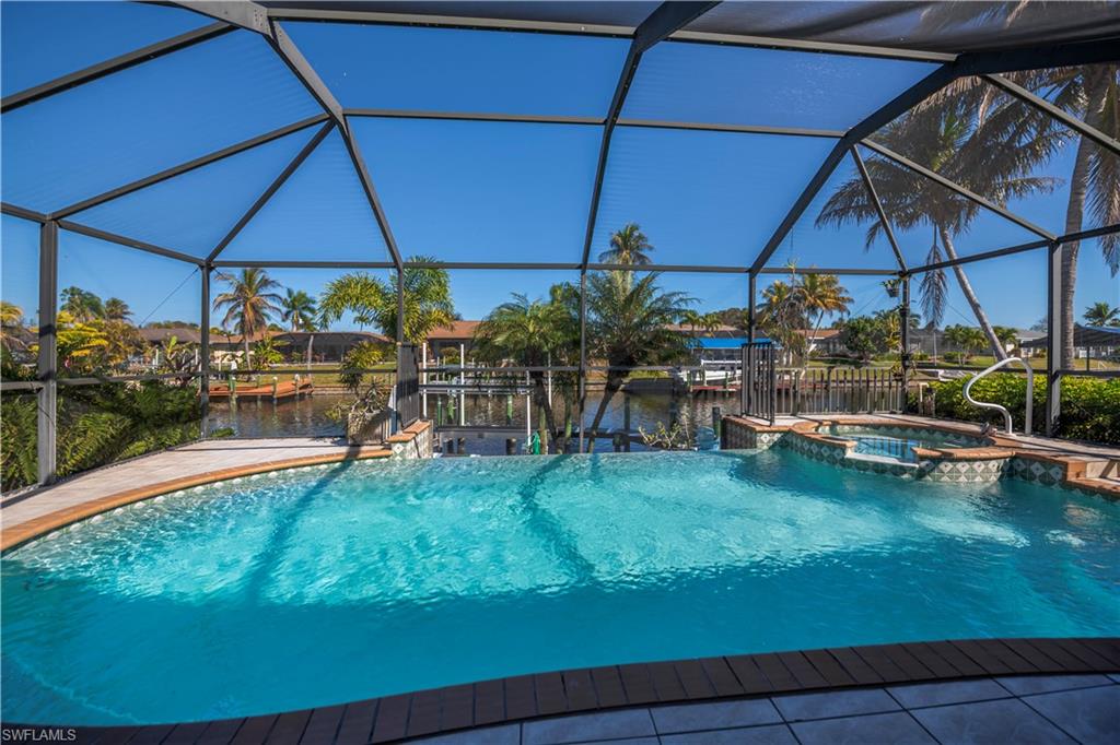 Integrated pool / spa featuring a lanai, a sunroom, and a water view