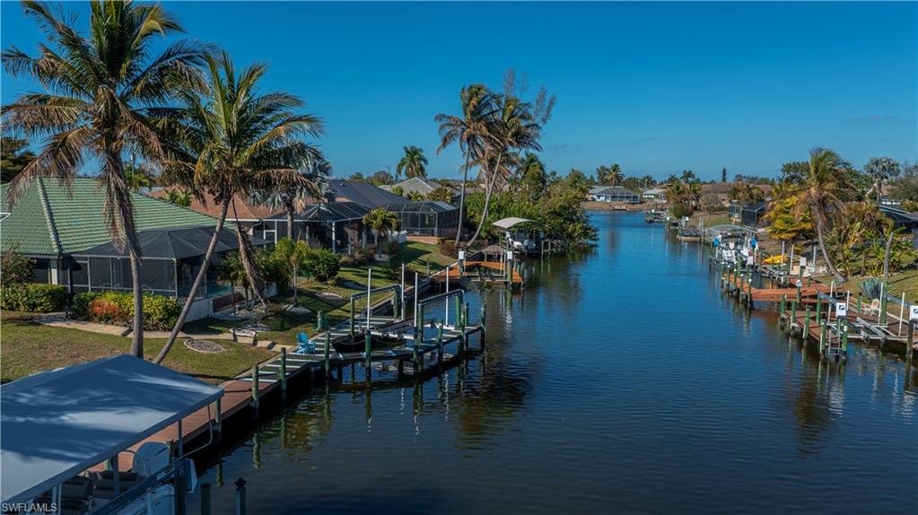 Dock area featuring boat lift, a water view, and a sunroom