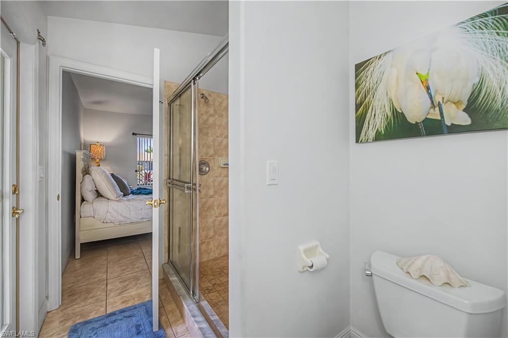Ensuite bathroom with a shower stall and light tile patterned floors