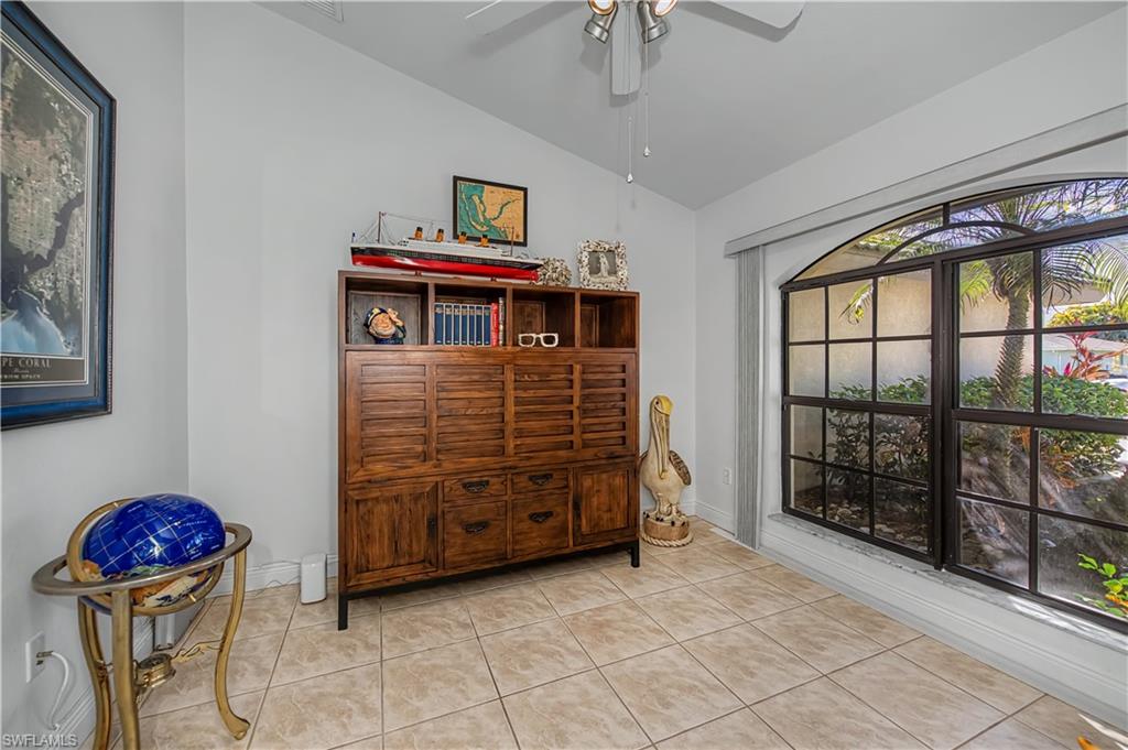 Sitting room with lofted ceiling, a ceiling fan, and tile patterned floors