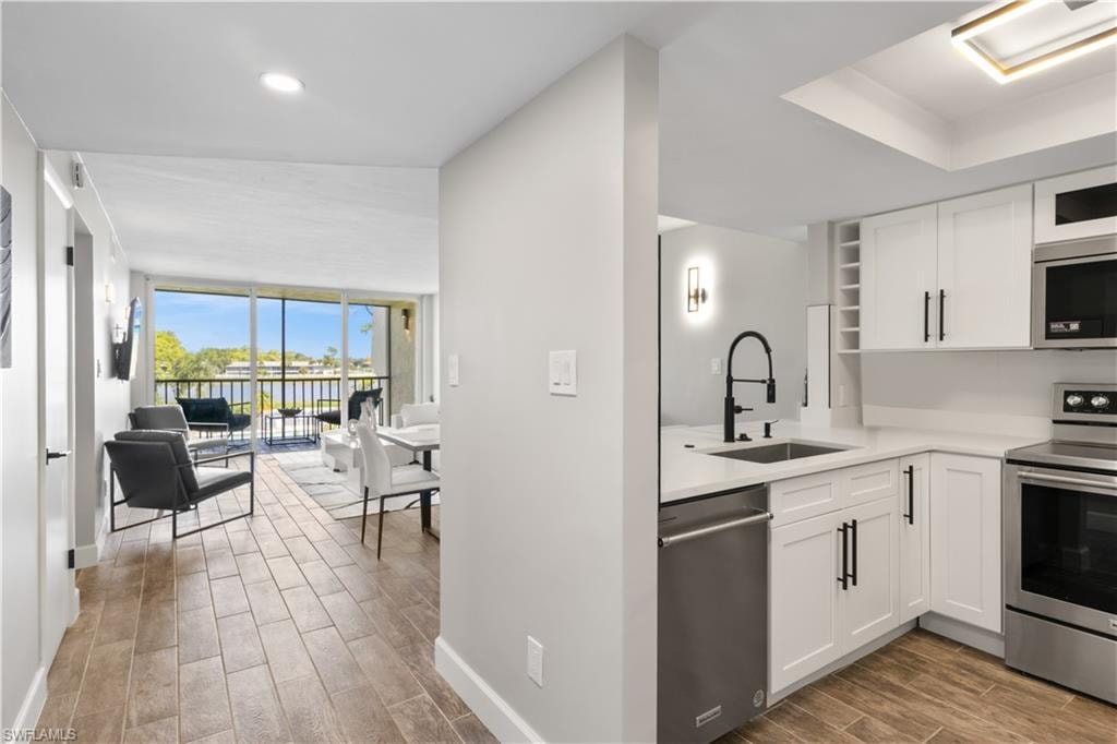 Upon entering, you’re immediately greeted by an open-concept kitchen and living area bathed in natural light, with stunning long lake views stretching beyond the windows!