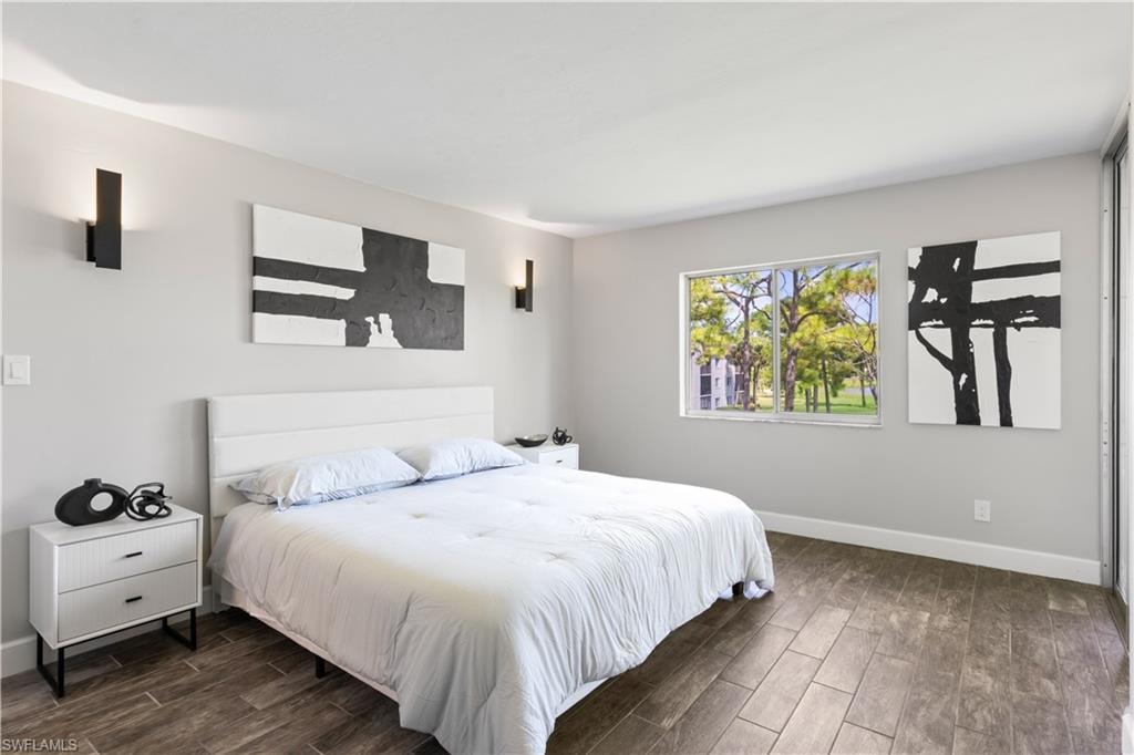 Serene primary suite with easy lanai access, inviting fresh air and beautiful lake views into the space.