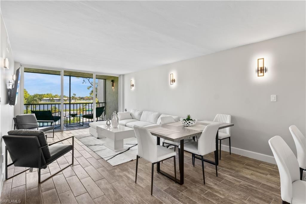 Modern living and dining room combination, thoughtfully furnished with brand new pieces and framed by tranquil lake views.