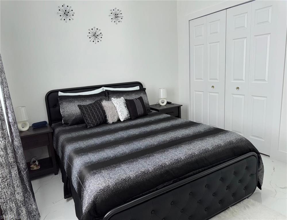 Bedroom with a closet and marble finish floor
