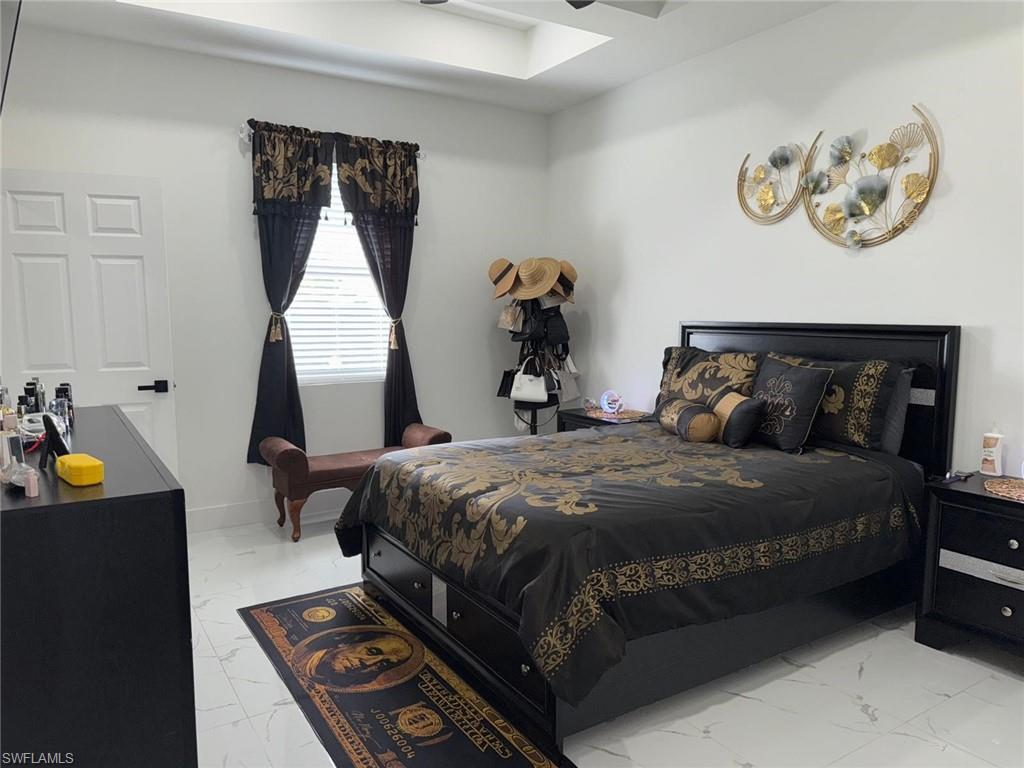 Bedroom featuring baseboards and marble finish floor