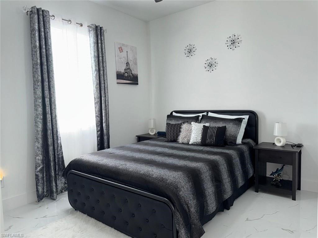 Bedroom with marble finish floor and baseboards