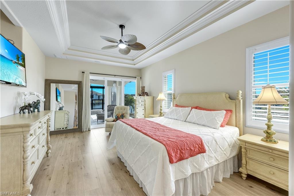 Bedroom with access to exterior, light wood-type flooring, ornamental molding, a ceiling fan, and multiple windows