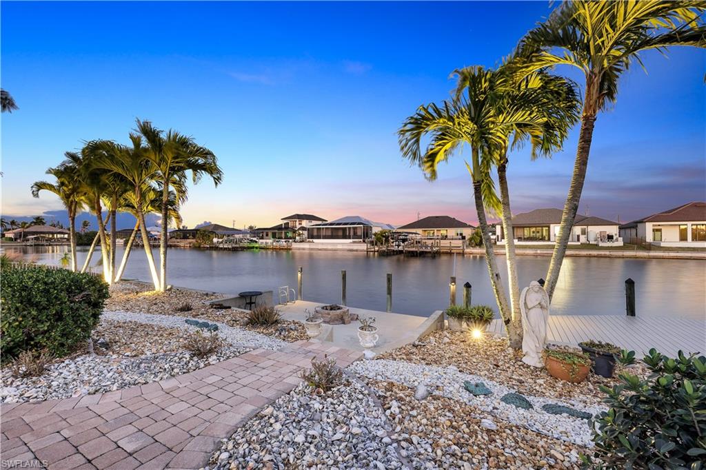 Water view featuring nearby suburban area and a dock
