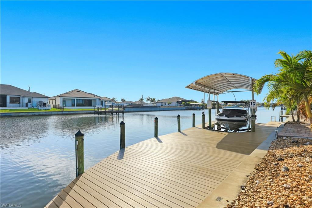 Dock with a water view, a residential view, and boat lift
