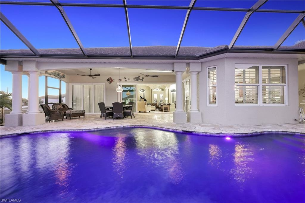 Outdoor pool featuring a sunroom, a lanai, a patio, and outdoor lounge area