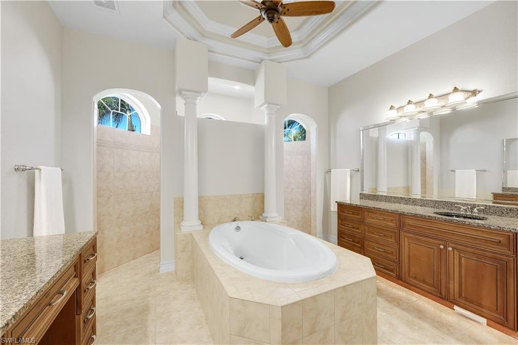 Bathroom featuring vanity, a walk in shower, a garden tub, crown molding, and ceiling fan
