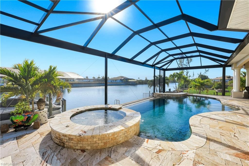 Integrated pool / spa with a sunroom, glass enclosure, a patio, and a water view