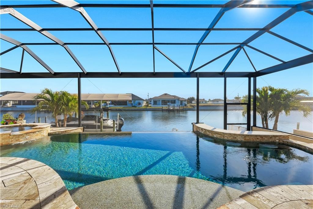 Combined pool / hot tub with a lanai, a sunroom, a boat dock, a residential view, and boat lift
