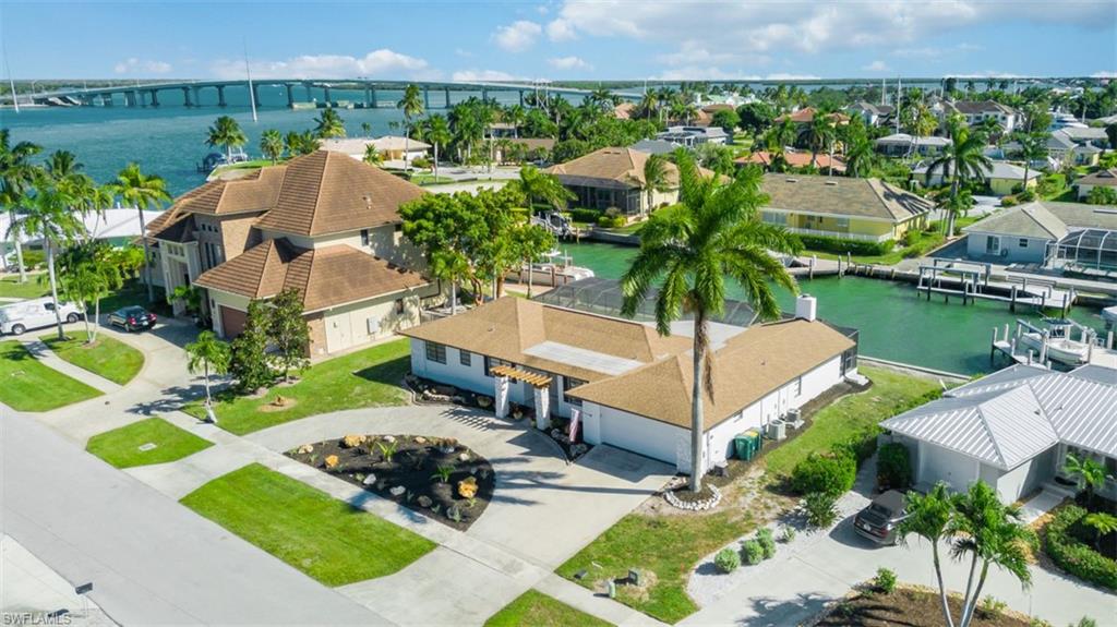 Aerial perspective of suburban area featuring a large body of water and a notable bridge