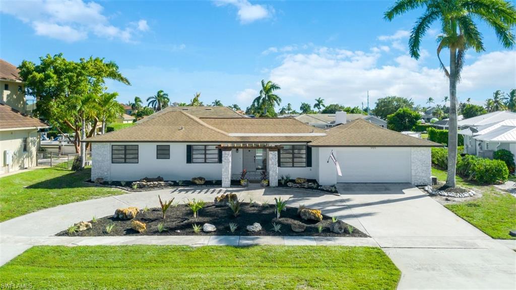 Single story home featuring driveway, roof with shingles, a garage, and stucco siding