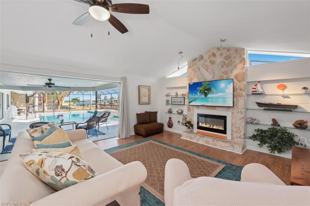 Living room featuring a sunroom, a ceiling fan, plenty of natural light, and wood finished floors