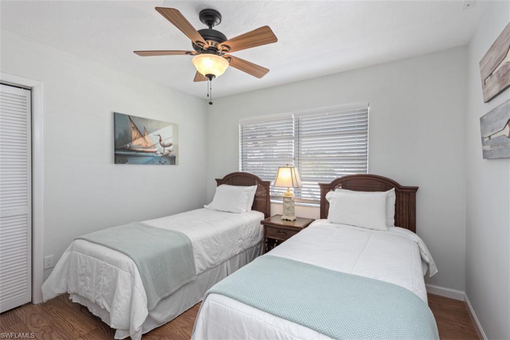 Bedroom with wood finished floors, a ceiling fan, and a closet