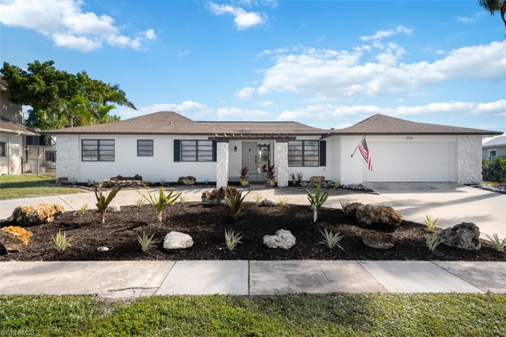 Ranch-style house featuring concrete driveway, an attached garage, and stucco siding