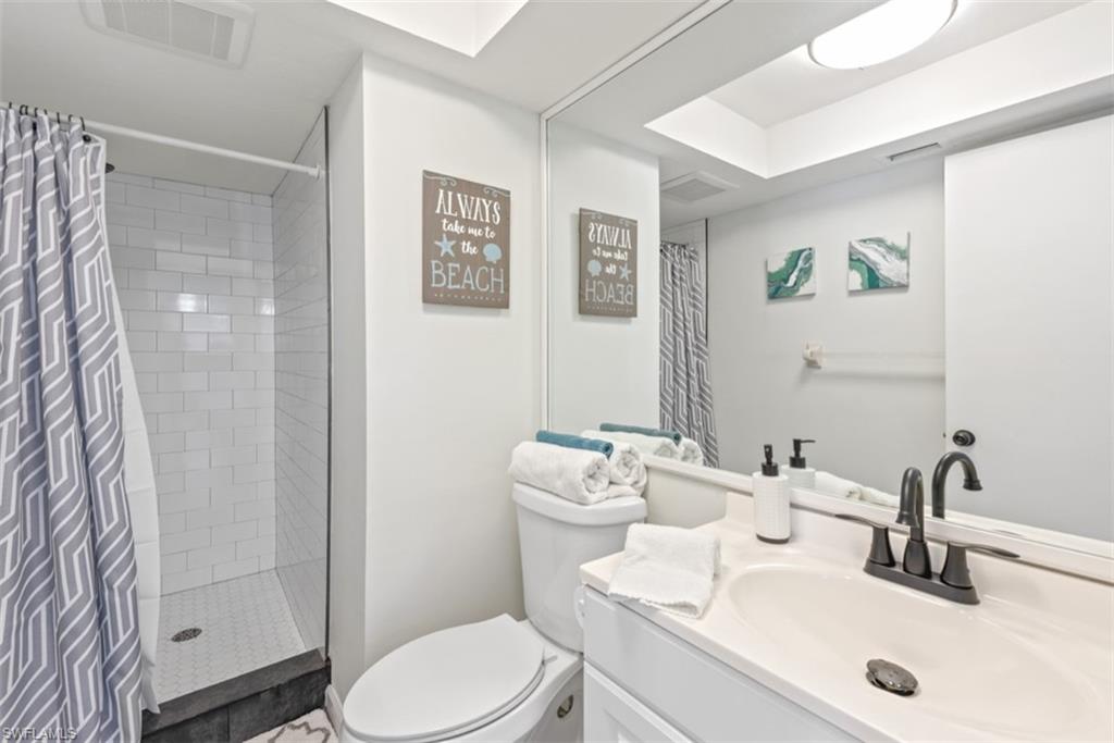 Full bath with a shower stall and vanity