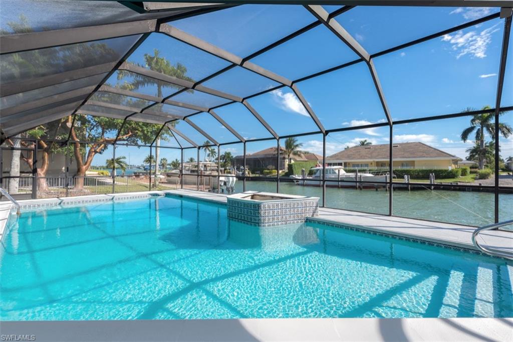 Swimming pool featuring a sunroom, a lanai, and a water view