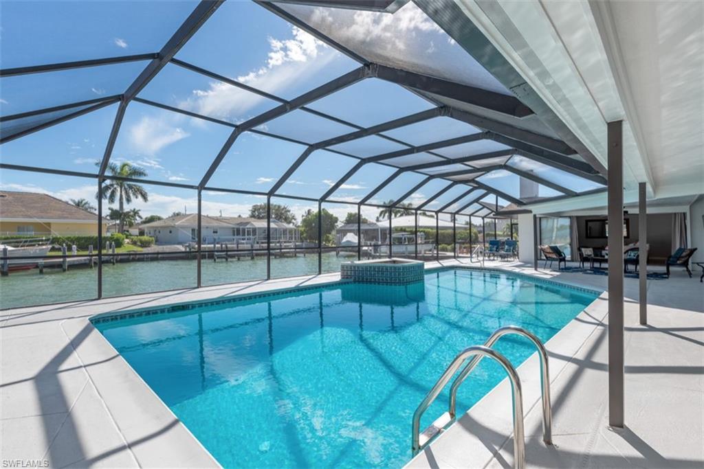 Outdoor pool featuring a patio, a lanai, a sunroom, and a residential view