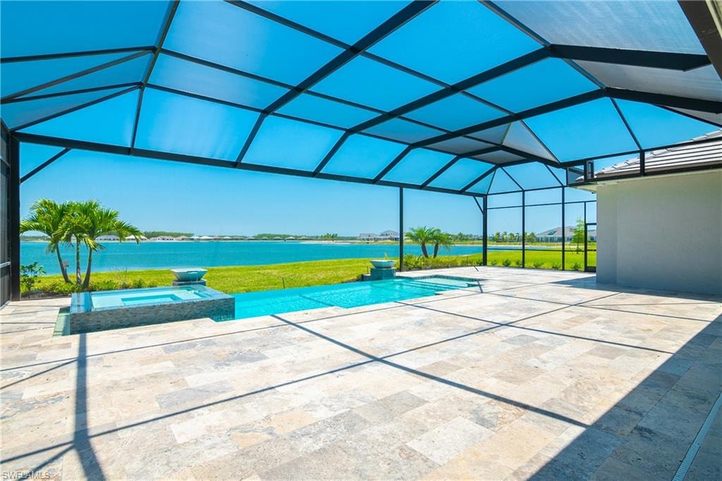 Integrated pool / spa featuring a sunroom, a patio area, a water view, a yard, and glass enclosure