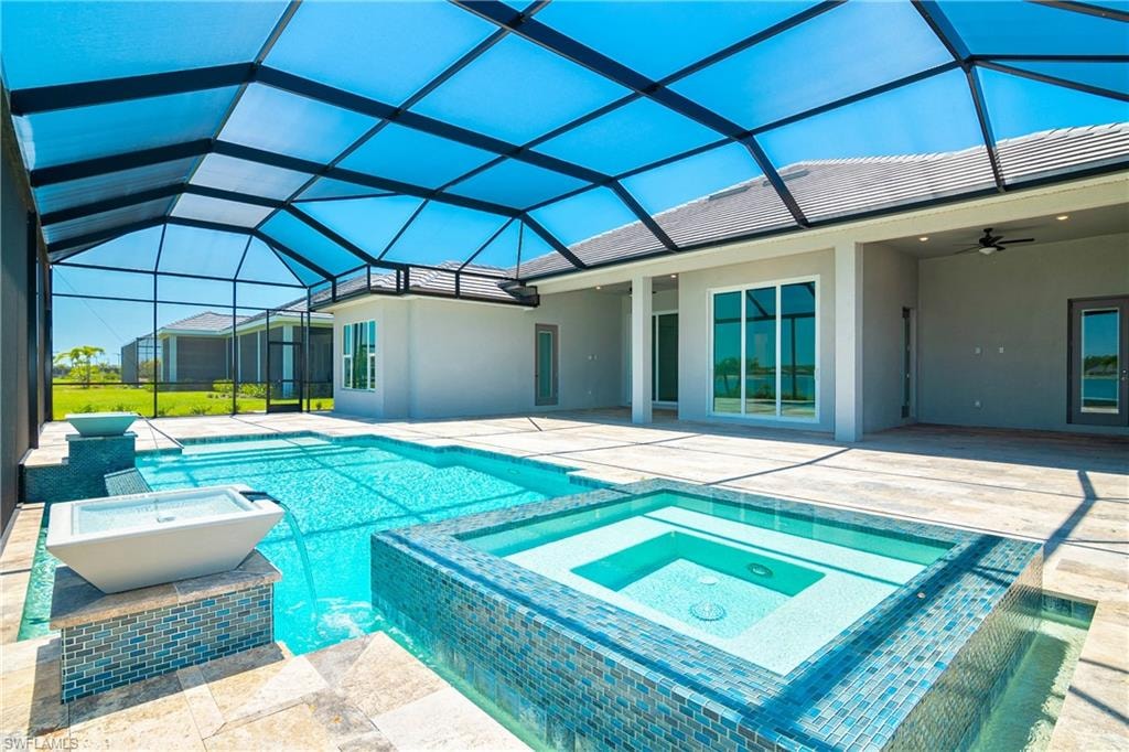 Integrated pool / hot tub featuring a sunroom, a patio, and glass enclosure