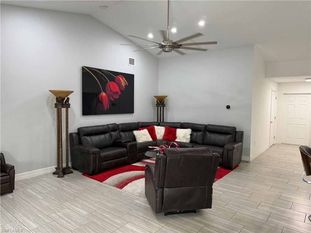 Living room with wood finish floors, a ceiling fan, and lofted ceiling