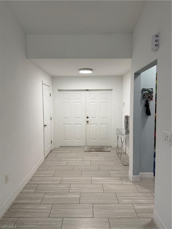 Corridor with baseboards and wood tiled floors