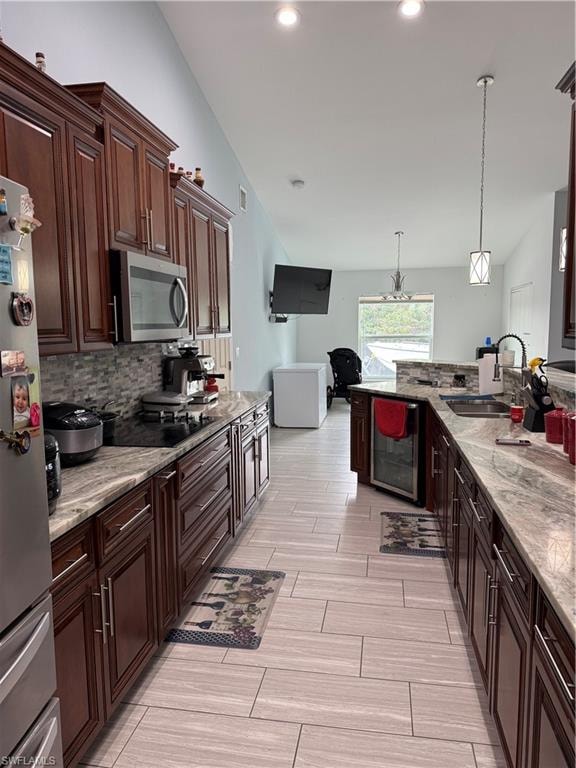 Kitchen featuring dark wood finish cabinetry, pendant lighting, and light stone countertops