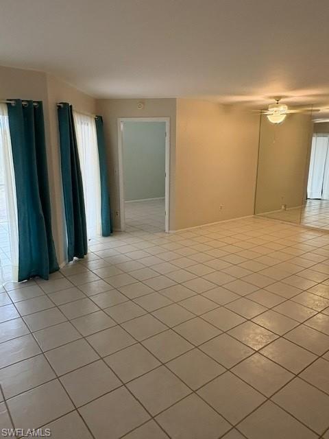 Unfurnished room with a ceiling fan and light tile patterned floors
