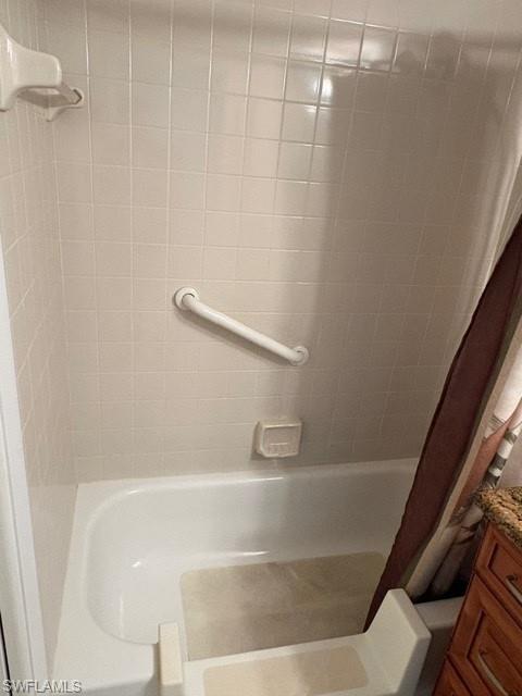 Bathroom featuring shower / bathtub combination with curtain and vanity